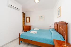 ネルハにあるBurriana Playa Carmona Nerjaのベッドルーム(青いベッド1台、木製テーブル付)
