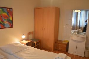 a bedroom with a bed and a sink and a cabinet at Hotel Wikinger Hof in Hamburg