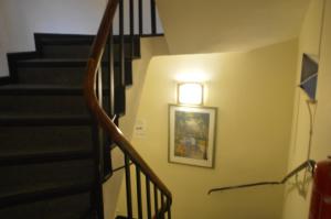 a hallway with a staircase with a light on the wall at Hotel Wikinger Hof in Hamburg