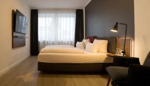 a hotel room with a large bed and a window at Hotel am Schlosstheater in Fulda