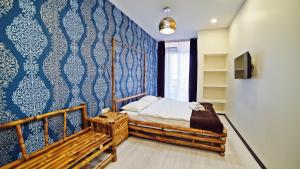 a bedroom with a bed and a blue wall at Plaza Inn Batumi in Batumi