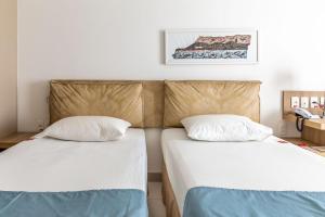 two beds sitting next to each other in a room at Iu-á Hotel in Juazeiro do Norte