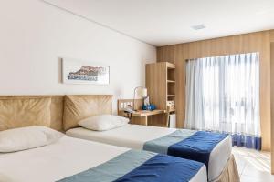 Cette chambre comprend 2 lits et une fenêtre. dans l'établissement Iu-á Hotel, à Juazeiro do Norte