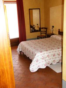 een slaapkamer met een bed, een spiegel en een raam bij Agriturismo Greppi in Crescentino