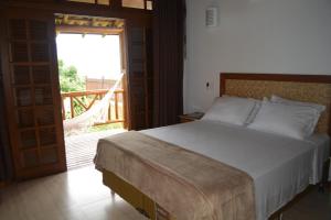 a bedroom with a large bed and a balcony at Gidu Ilhabela in Ilhabela