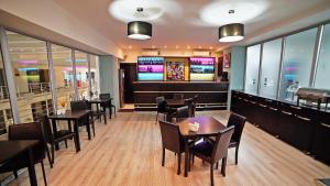 a dining room with tables and chairs and televisions at Plaza Inn Batumi in Batumi