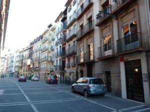 un coche aparcado en una calle frente a los edificios en Apartamento Berria, en Pamplona