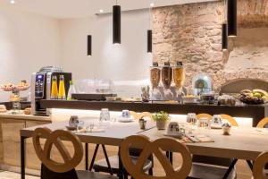 a kitchen area with a table and chairs at Hotel KLE, BW Signature Collection in Kaysersberg