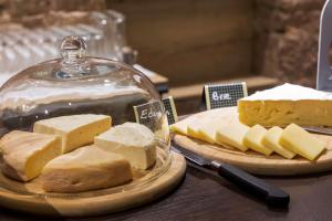 a plate of cheese on a table with a glass dome at Hotel KLE, BW Signature Collection in Kaysersberg