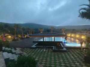 - une piscine avec un kiosque à côté du complexe dans l'établissement Regenta Resort Belagavi, à Belgaum