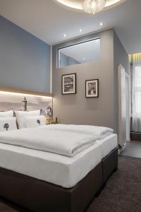 a large bed in a bedroom with a large window at Aparthotel by dasPaul in Nürnberg