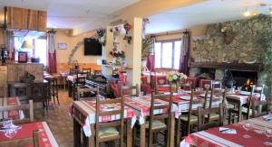 a restaurant with tables and chairs and a fireplace at Hotel - Restaurant Le Blanchon in Selonnet