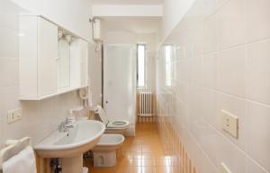 Baño blanco con aseo y lavamanos en Residence Stella Marina, en Cupra Marittima