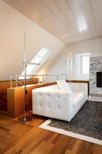 a white couch in a living room with a fireplace at Widder Hotel - Zurichs luxury hideaway in Zurich