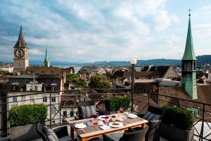 einen Tisch auf einem Balkon mit Stadtblick in der Unterkunft Widder Hotel - Zurichs luxury hideaway in Zürich