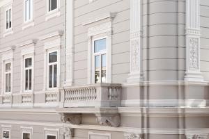 a white building with a balcony on the side of it at Palazzo Talenti 1907 in Trieste