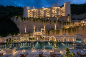 a hotel with a pool in front of a building at Aurika, Udaipur - Luxury by Lemon Tree Hotels in Udaipur