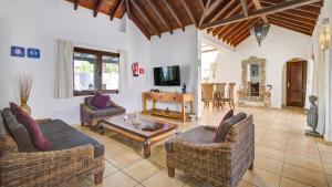 a living room with two couches and a tv at Villa Sávila in Caleta De Fuste