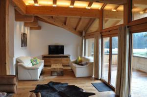 a living room with two couches and a tv at Seebach Chalets in Scheffau am Wilden Kaiser