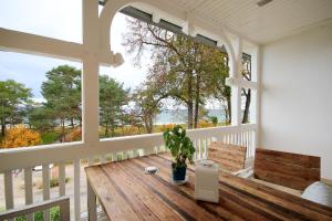 une terrasse couverte avec une table en bois et une plante en pot. dans l'établissement Aparthotel Ostsee by Rujana, à Binz