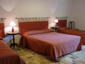 a bedroom with two beds and two tables with lamps at La Durlindana B&B in Acireale
