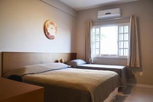 a bedroom with two beds and a window at CASA PRAIA A 600m DO MAR in Balneário Camboriú