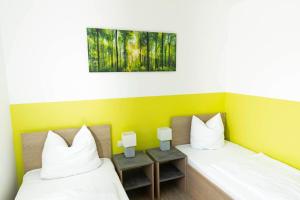 two beds in a room with yellow and green walls at Green Guest House in Wörth an der Isar