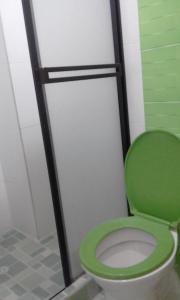 a green toilet in a bathroom with a shower at Hotel El Principe Sede Campestre in Ocaña