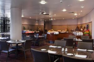 a restaurant with tables and chairs and a bar at Crown Hotel in Port Moresby