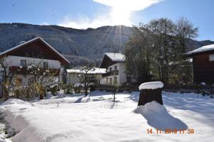een huis in de sneeuw met de zon op de achtergrond bij Apartment Nagiller in Rinn