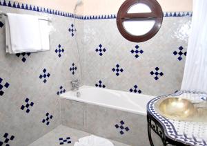 ein blau-weißes Bad mit einer Badewanne und einem Stuhl in der Unterkunft Suite Hotel Tilila in Agadir