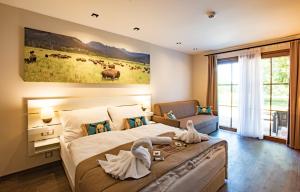 um quarto com uma cama grande com cisnes em Residence Safari Resort - Bison Lodge em Borovany
