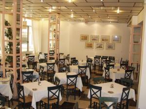 a dining room with white tables and chairs at Ilis Hotel in Olympia