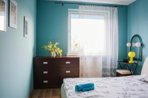 a bedroom with blue walls and a bed and a window at Rainbow z prywatnym parkingiem in Bielsko-Biała
