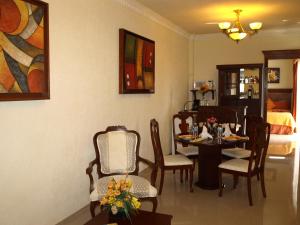a dining room with a table and chairs and a bedroom at Gran Real Yucatan in Mérida