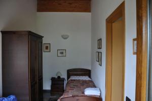 Agriturismo Dazze في Marcheno: غرفة نوم صغيرة مع سرير في غرفة