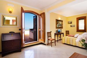 a bedroom with a bed and a tv and a balcony at Hotel Villa La Colombaia in Agropoli