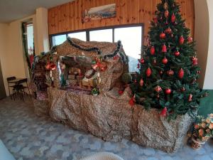 ein Weihnachtsbaum und ein Lebkuchenhaus in einem Zimmer in der Unterkunft Royal Guest House in Nazareth