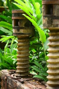 a stone tower sitting in front of some plants at Hotel Boutique Perainda in Trancoso