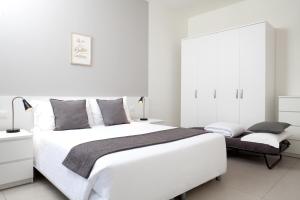a white bedroom with a large bed and white cabinets at Palazzo Talenti 1907 in Trieste