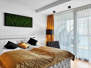 um quarto com uma cama e uma grande janela em Sea View Moss VIP Apartment em Kolobrzeg