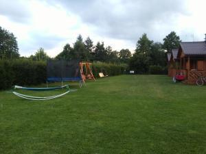 a large yard with a playground and a house at Domki Letniskowe Zygmunt in Kopalino