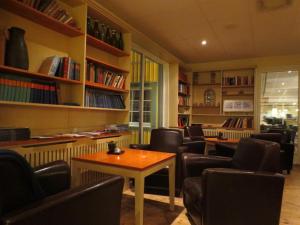 uma sala de espera com cadeiras, uma mesa e livros em Dinners em Arboga