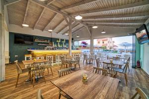 um restaurante com mesas e cadeiras de madeira e um bar em Emi Seaside em Amoudara Herakliou