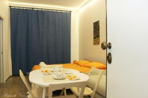 サレルノにあるSEAFRONT APARTMENT SALERNOのベッド付きの客室で、白いテーブルと椅子が備わります。