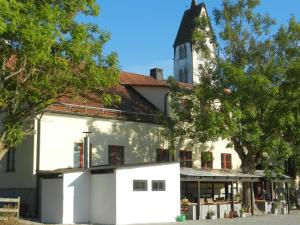 a white building with a clock tower in the background at Gothem Logi in Gothem
