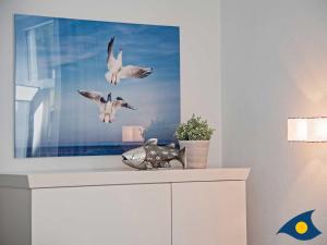 two birds flying over a dresser in a room at Villa Lucie Else Whg 04 Backbord in Heringsdorf