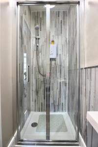 a shower with a glass enclosure in a bathroom at Ivy Cottage Bed & Breakfast in Reeth