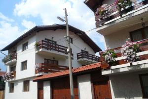 un edificio con cajas de flores y balcones en él en Guest Rooms Vachin en Bansko