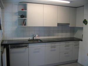 a kitchen with white cabinets and a sink at Ferienhaus Ahorn in Flumserberg
